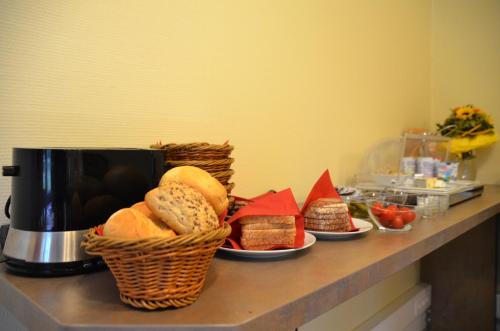 a counter with baskets of bread and a coffee maker at Hotel Villa Kisseleff in Bad Homburg vor der Höhe