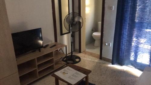a living room with a television and a desk with a fan at Le Malte House St. Julians in St Julian's