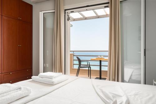 a bedroom with a bed with a view of the ocean at Glyfa Beach Villas in Barbati