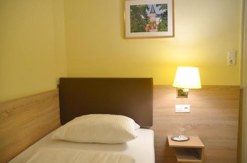 a bedroom with a bed and a lamp and a table at Hotel Villa Kisseleff in Bad Homburg vor der Höhe