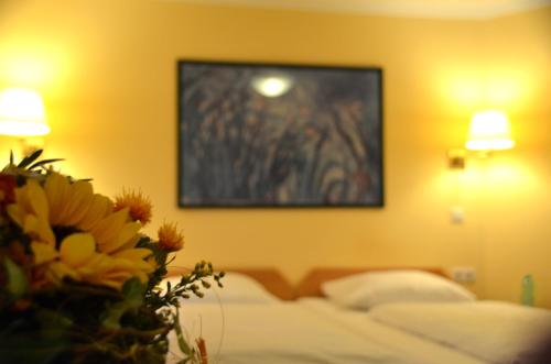 a bedroom with a bed with a vase of flowers at Hotel Villa Kisseleff in Bad Homburg vor der Höhe