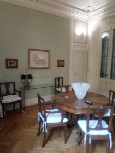 a dining room with a wooden table and chairs at B&B Palazzo Bianchi in Parma