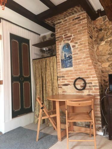 - une table et des chaises dans une pièce dotée d'un mur en briques dans l'établissement Tim's secret place, à Honfleur