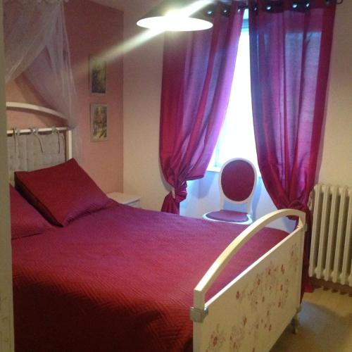 une chambre avec un lit avec des rideaux violets et une fenêtre dans l'établissement La ferme de Manon, à Bozouls