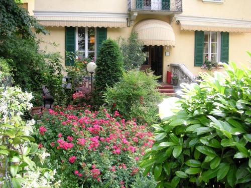 a garden in front of a house with pink flowers at Hotel Giglio in Salsomaggiore Terme