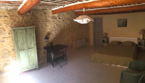 1 dormitorio con 1 cama y 1 mesa en una habitación en La Magnanerie, en Bonnieux