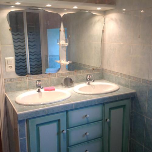 une salle de bain avec deux lavabos et un miroir dans l'établissement La ferme de Manon, à Bozouls