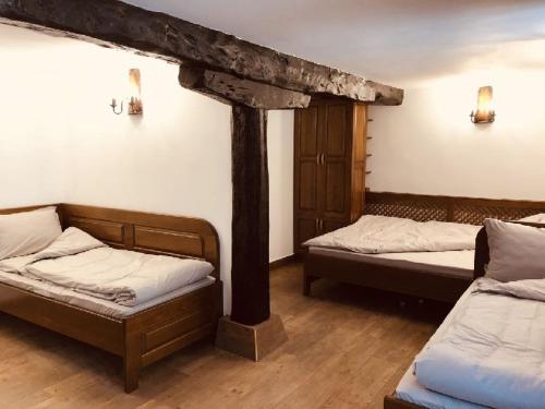 dwa łóżka w pokoju z wiązką w obiekcie Guest House Ivan w mieście Cherni Osŭm