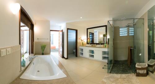 Un baño grande con bañera y ducha. en Superbe Villa privée, en Flic en Flac