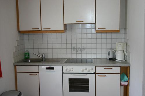 a kitchen with a sink and a stove at Ferienwohnung Christina Gundolf in Wenns