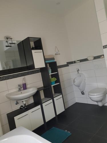 a bathroom with a sink and a toilet and a urinal at Ferienwohnung an der Unditz 2 in Neuried