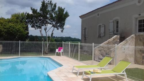 un patio avec deux chaises et une piscine dans l'établissement Terra Gasconha, à Barbaste