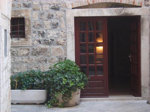 a door to a building with two potted plants in front at Rooms Roso in Trogir
