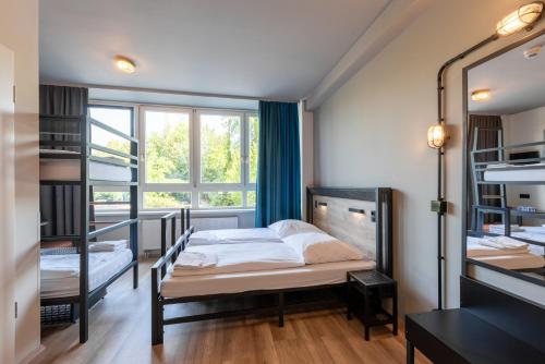 a bedroom with two bunk beds and a window at a&o Hamburg City in Hamburg