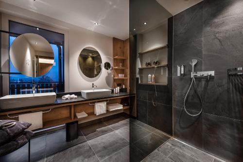 a bathroom with a shower and a sink and a mirror at DolceVita Hotel Jagdhof in Laces