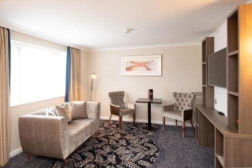 a living room with a couch and two chairs at Burleigh Court Hotel and Leisure in Loughborough