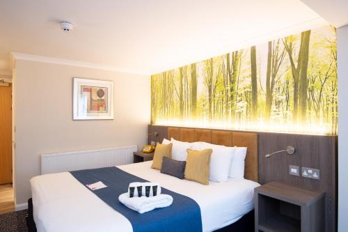 a bedroom with a bed with a large window at Burleigh Court Hotel and Leisure in Loughborough