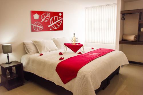 a bedroom with a large bed with a red blanket at HOTEL OLIMPIA in Duitama