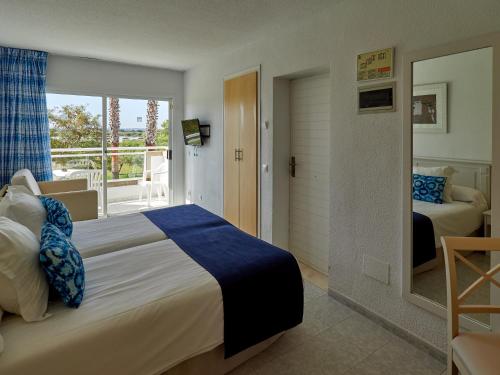 sypialnia z dużym łóżkiem i balkonem w obiekcie BQ Alcudia Sun Village w Playa de Muro