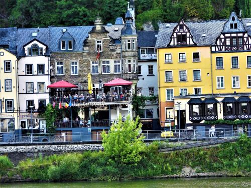 eine Gruppe von Gebäuden neben einem Fluss in der Unterkunft Pension Winnemuller in Cochem