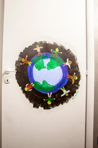 a painting of people around the earth on a refrigerator at Il Giramondo in Busca
