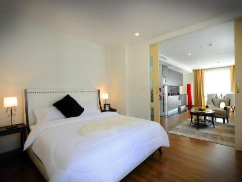 a hotel room with a large bed and a large window at The Bless Hotel and Residence in Bangkok