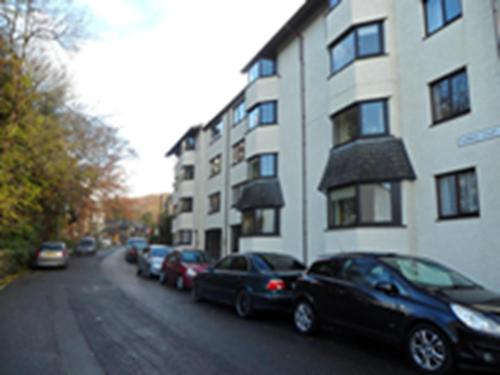 a row of cars parked on a street next to a building at Howgill in Windermere