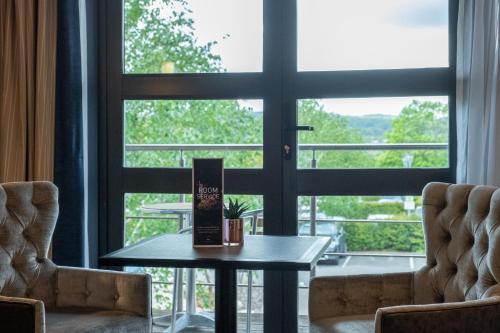 a table and two chairs in front of a window at Burleigh Court Hotel and Leisure in Loughborough