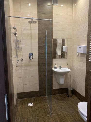 a bathroom with a glass shower and a sink at Apartament "Marka" in Piła