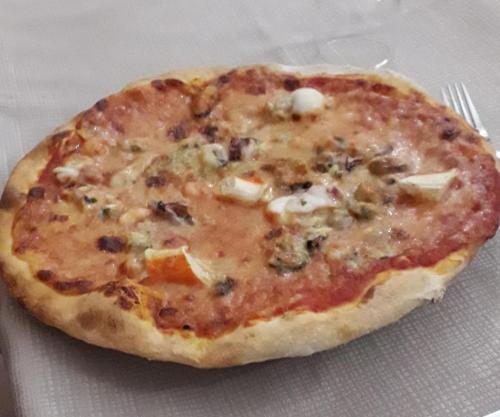 a pizza sitting on top of a table with a fork at Da Santo Hotel Ristorante Pizzeria in Ferrara