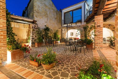 an outdoor patio with tables and chairs and plants at Domo Pro Vois in Orosei