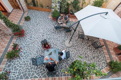 two people sitting at a table with an umbrella at Domo Pro Vois in Orosei