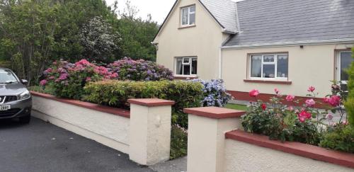 ein Haus mit Blumen an einer Mauer in der Unterkunft Seabreeze Apartment in Westport