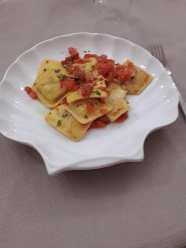 a plate of ravioli with tomatoes on a table at Da Santo Hotel Ristorante Pizzeria in Ferrara