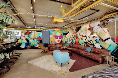 a living room with a couch and a colorful wall at Hotel the Match in Eindhoven