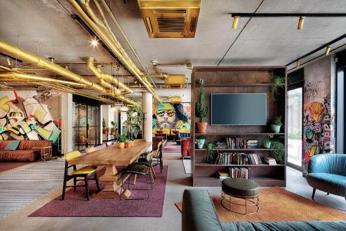 a living room with a wooden table and a tv at Hotel the Match in Eindhoven
