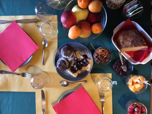 a table topped with bowls of fruit and a plate of cake at Agriturismo Becerca Vegan in Serra San Quirico