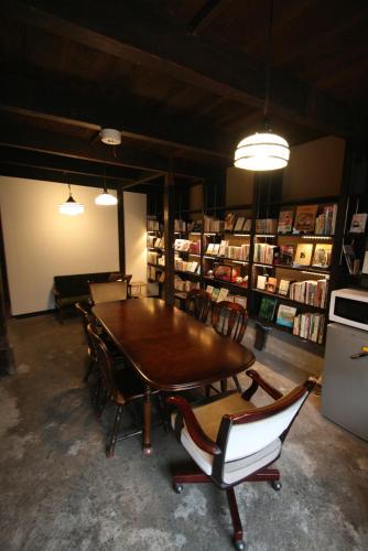 a room with a table and chairs in a library at HARUYA Umekoji in Kyoto