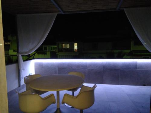 a table and chairs on a balcony at night at Via Ziino 70 in Oliveri