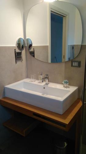 a bathroom sink with a large mirror above it at Via Ziino 70 in Oliveri