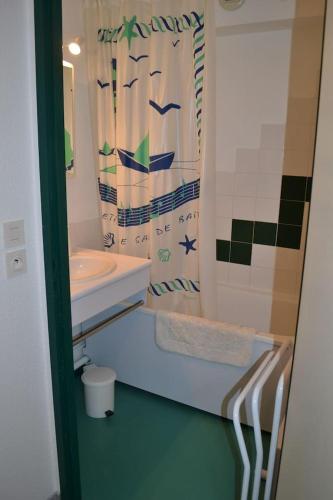 une salle de bain avec un lavabo et un rideau de douche dans l'établissement Appartement à 50m de la plage, à Soorts-Hossegor