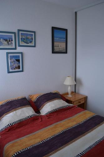 une chambre avec un lit et une table avec une lampe dans l'établissement Appartement à 50m de la plage, à Soorts-Hossegor