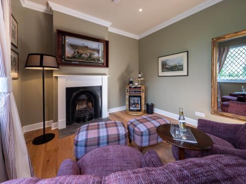 a living room with a couch and a fireplace at SCHLOSS Roxburghe, part of Destination by Hyatt in Kelso