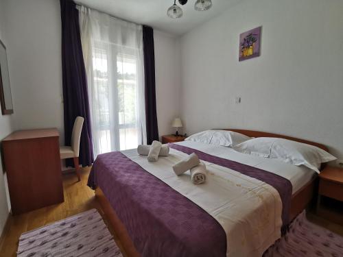 a bedroom with a large bed with towels on it at Apartments Andrijašević in Makarska