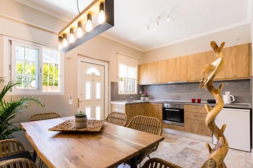 een keuken met een houten tafel en stoelen bij Rarakos Houses Corfu in Corfu-stad