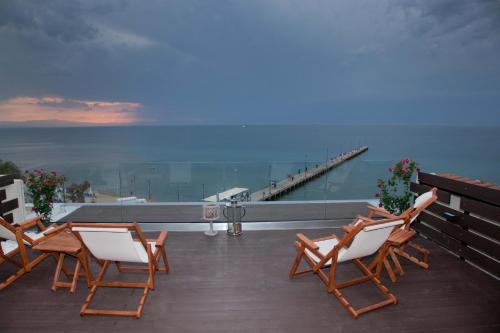 a group of chairs sitting on a deck with a pier at Vento di Mare in Perea