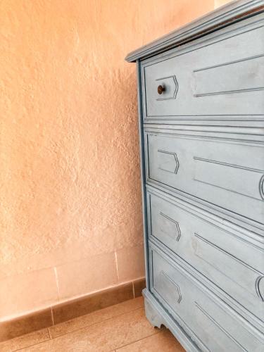 a blue chest of drawers next to a wall at BnB Le Janas in Càbras