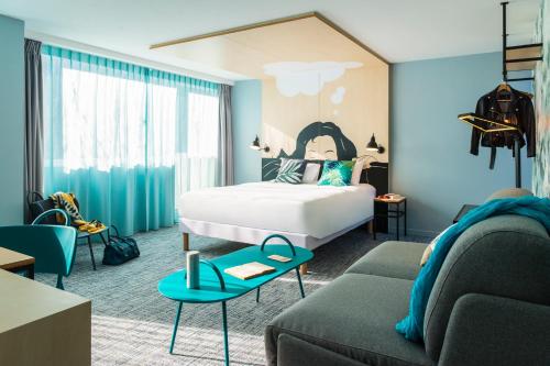 a bedroom with a bed and a living room at ibis Styles Louvain-la-Neuve Hotel and Events in Louvain-la-Neuve