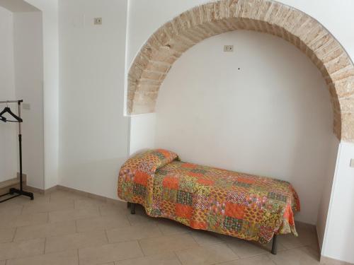 uma arcada num quarto branco com um cobertor no chão em Nonna Livia em Alberobello