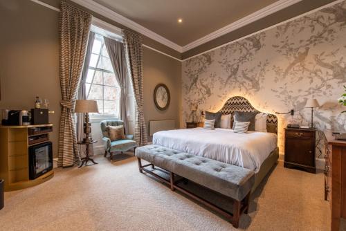 a bedroom with a large bed and a chair at SCHLOSS Roxburghe, part of Destination by Hyatt in Kelso